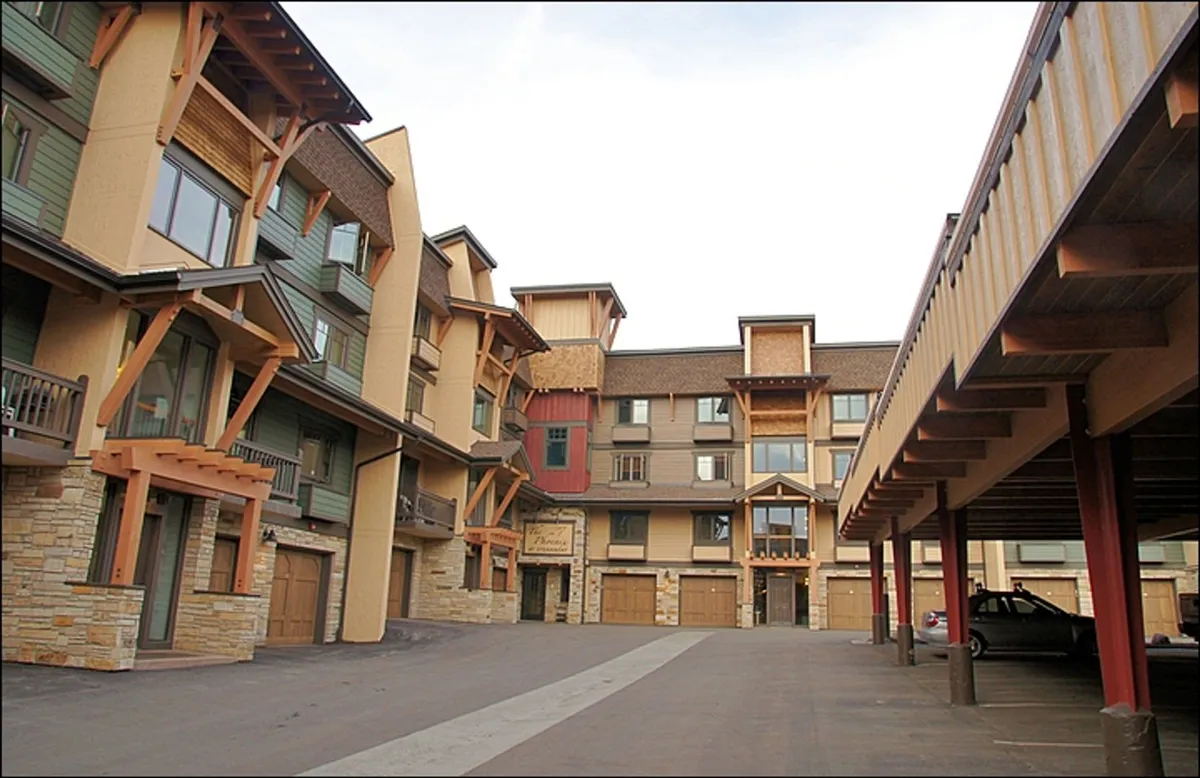 The open courtyard area of the building, showcasing attractive architectural details with wood and stone textures. The communal space is set up for gatherings, with plenty of room for guests to mingle and enjoy outdoor activities. The design emphasizes a welcoming, community-oriented atmosphere.